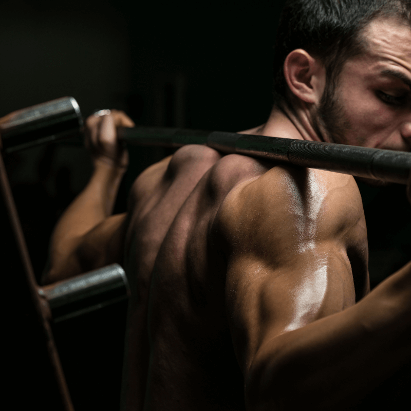 A man using a squat rack for strength training, showcasing the Ideal Squat Rack for Your Home Gym.