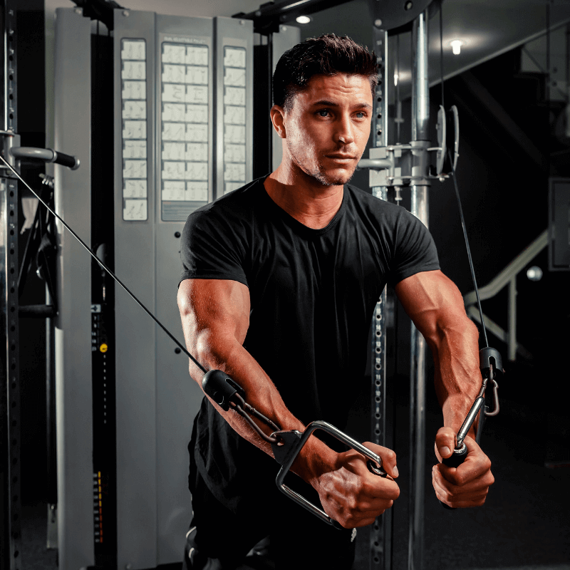 The Essential Guide to Functional Trainers: person using a functional trainer machine for strength training in a gym.